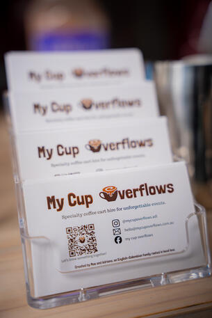 A stack of business cards displaying the My Cup Overflows logo and a QR code.