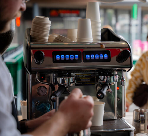 The back panel of an Expobar Mega Crema espresso machine with blue digital display screens.